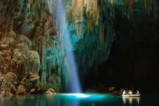 Rio de águas cristalinas em Bonito, Mato Grosso do Sul, cercado por vegetação nativa e peixes visíveis sob a superfície.