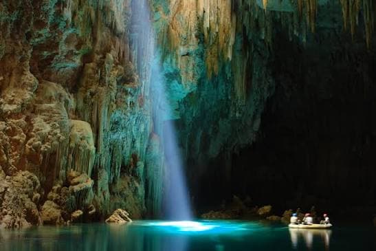 Rio de águas cristalinas em Bonito, Mato Grosso do Sul, cercado por vegetação nativa e peixes visíveis sob a superfície.